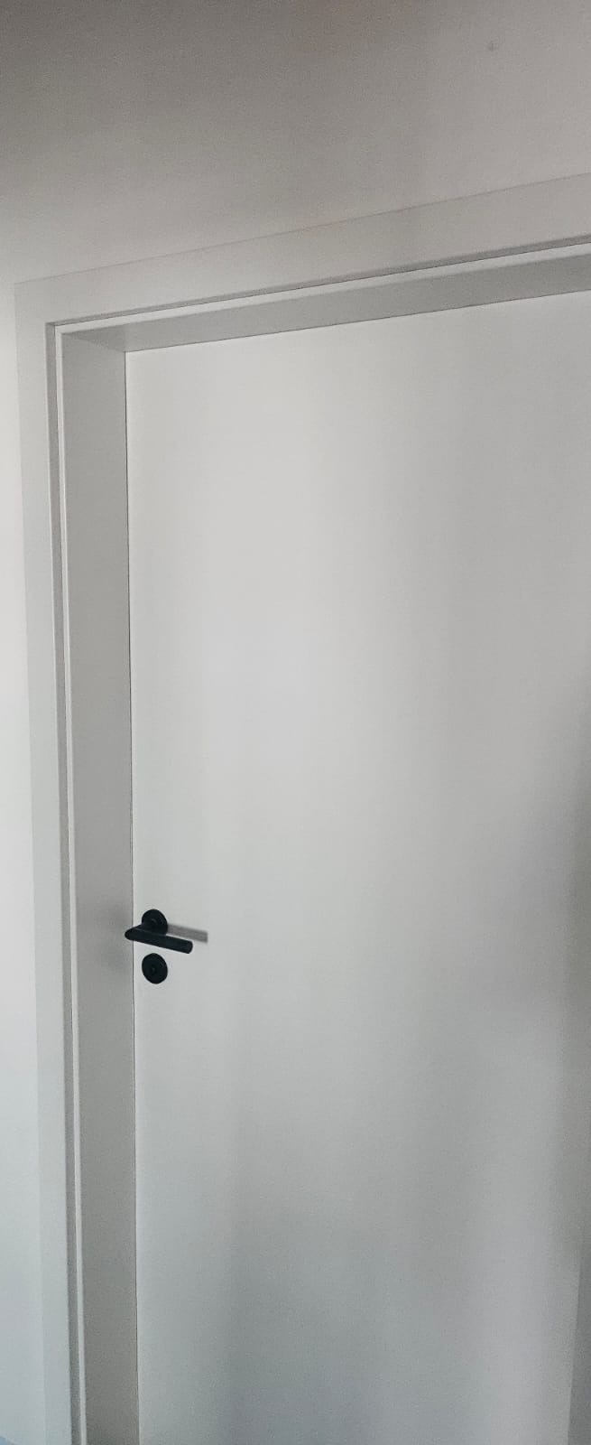 Weiße Innentür mit schwarzem Griff